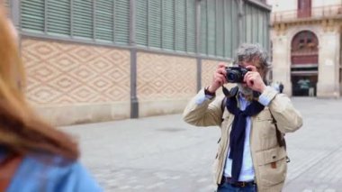 Kıdemli yetişkin bir adam yaz tatilinde karısına fotoğraf çekiyor. Olgun turist çiftimiz Avrupa 'da tatilin tadını çıkarıyor..