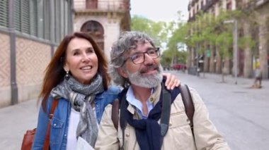 Barcelona 'ya seyahat sırasında şehir haritasında yer arayan mutlu emekli turist çifti. Emeklilik ve tatilci olgun insanlar konsepti.