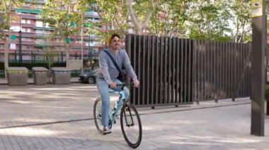 Genç hippi adam işe bisikletle gidip geliyor. Şehir içi ulaşım ve sürdürülebilir ulaşım kavramı.