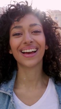 Şehir sokağında kameraya gülümseyen güzel, neşeli, genç Müslüman kadın. Mutlu Arap kadın portresi. Dikey bireysel görüntüler.