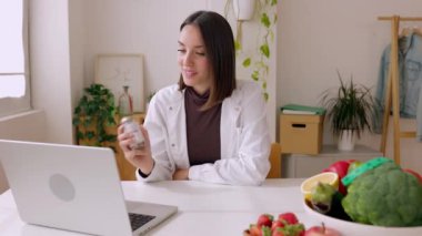 Hastanedeki bilgisayardan hastayla görüntülü konuşma yapan bir sağlık görevlisi. Mutlu doktor kadın bilgisayar kullanıyor, online tıbbi destek veriyor, tavsiye veriyor, danışmanlık yapıyor..