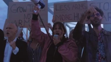 Dünyada savaş ve şiddeti protesto eden çeşitli aktivist grupları posterler ve pankartlar taşıyorlar..