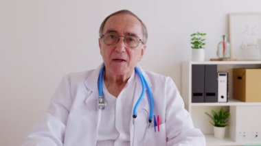 Hastanedeki tıbbi konsültasyondan gelen dizüstü bilgisayarla hastayla konuşan yaşlı erkek doktorların POV 'u. Klinik yardım ve teletıp kavramı. 