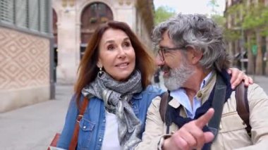 Barcelona 'ya seyahat sırasında şehir haritasında yer arayan mutlu emekli turist çifti. Emeklilik ve tatilci olgun insanlar konsepti.