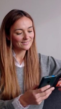 Kredi kartı ve cep telefonu tutan mutlu genç bir kadın banka işlemleri ya da online alışveriş yapıyor. Çevrimiçi ödeme için akıllı telefon kullanan mutlu bayan müşteri. 