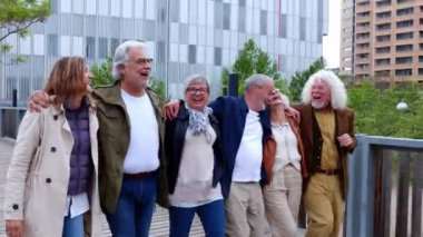 Son sınıf emeklileri, şehir caddesinde yürürken birbirlerine sarılıp eğleniyorlar. Emeklilik ve yaşlılık arkadaşlık kavramı.