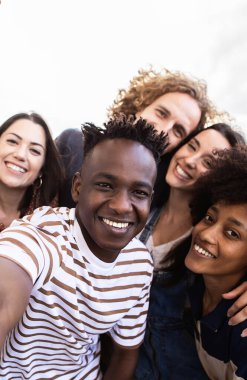 Bir grup mutlu insanın dışarıda selfie çekerken çekilmiş dikey görüntüleri. Milenyum çeşitliliğinde en iyi arkadaşlar tatilde eğleniyor. Gençlik toplumu ve arkadaşlık kavramı.