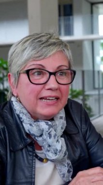 Bar terasında arkadaşlarıyla kahve içen olgun bir kadının portresi. Üst düzey emekli insanlar sosyal toplanma sırasında sıcak kahve içerek eğleniyorlar. Emeklilik yaşam tarzı kavramı.