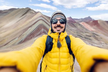 Vinicunca Dağı, Peru 'da selfie çeken mutlu genç bir gezgin. Rainbow Dağı, Cuzco Bölgesi. Seyahat ve Güney Amerika manzara konsepti