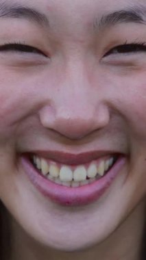 Açık havada gülümseyen Asyalı genç kadın portresi. Mutlu Milenyum Çinli kadın şehir parkında kameraya bakıyor. Dikey HD video. Pozitif insanlar konsepti.