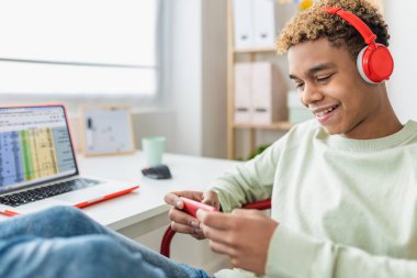 Genç çocuk odasında video oyunu oynarken eğleniyor. Boş zaman aktiviteleri ve gençlik yaşam tarzı konsepti.