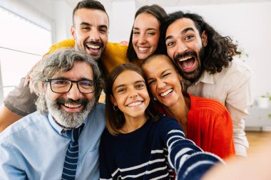 Kafkasyalı mutlu bir aile evde selfie portresi konuşuyor. Kameraya gülümseyen çok nesilli bir grup yurtiçi odada toplandı..