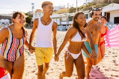 Mutlu genç arkadaş grubu sahilde yaz tatilinin tadını çıkarıyor. Seyahat ve tatil yaşam tarzı kavramı