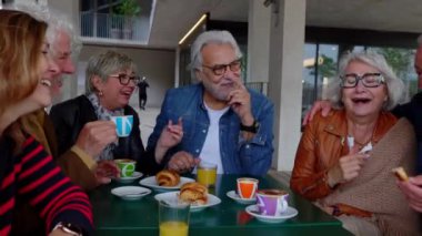 Yaşlı insanlar sabahları kafeterya barında kahvaltı yapıyorlar. Emekli bir grup yetişkin, hafta içi birlikte kahve içiyor. Emekli insanlar ve arkadaşlık kavramı.