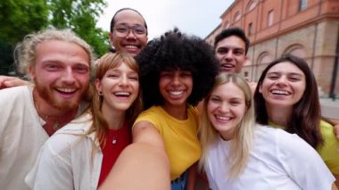 Kameraya gülümseyen bir grup genç arkadaş. Çok ırklı turistler, İtalya 'da yaz tatilinde selfie çekerken birbirlerine gülüyorlar. Arkadaşlık kavramı