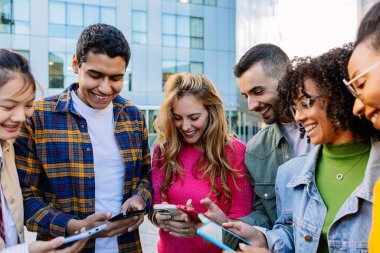 Üniversite kampüsünde cep telefonu kullanan bir grup öğrenci. Teknoloji yaşam tarzı konsepti.