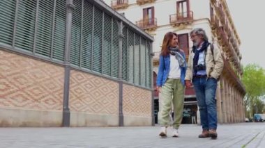 Tatil sırasında Barcelona 'da yürüyüş yaparken gülen mutlu son sınıf turistleri. Olgun arkadaşlar birlikte şehir sokağında eğleniyorlar. Emekli insanlar yaşam tarzı konsepti.