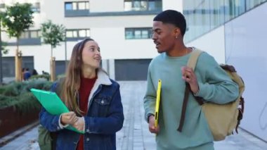 İki çok ırklı genç üniversite öğrencisi üniversite kampüsüne gelirken takılıyorlar. Eğitim ve gençlik yaşam tarzı kavramı.