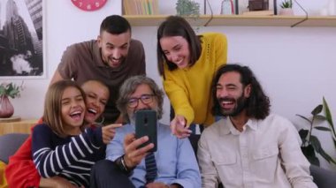 Çok nesildir cep telefonu kullanan bir aile evdeki kanepede yan yana oturuyor. Teknoloji ve ev hayatı kavramı.