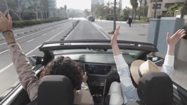 Mutlu genç çift şehirde üstü açık arabada yaz tatilinin tadını çıkarıyor. Kadın ve erkek dışarıda araba sürerken kahkaha atıyorlar. Seyahat ve tatil kavramı