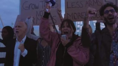 Dünyada savaş ve şiddeti protesto eden çeşitli aktivist grupları posterler ve pankartlar taşıyorlar..