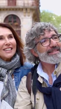 Barcelona 'ya seyahat sırasında şehir haritasında yer arayan mutlu emekli turist çifti. Emeklilik ve tatilci olgun insanlar konsepti. Dikey HD video.