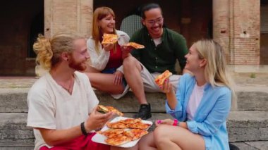 Farklı arkadaş grupları, İtalya 'da yaz tatilinin tadını çıkarırken birlikte pizza yiyorlar..