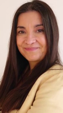 Ofiste duran orta yaşlı bir iş kadınının portresi. 50 'lerin girişimci kadını kameraya gülümsüyor ve kendine güveniyor. Güçlendirme ve liderlik kavramı. Dikey Hd videosu.