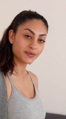 Spor giyim bölümünde elinde yoga minderiyle mutlu genç bir kadının portresi. Azim, spor ve sağlıklı yaşam tarzı kavramı.