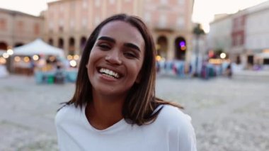 Şehir caddesinde gülümseyen çekici genç bir kadının portresi. Neşeli Afro-Amerikalı kız dişlek gülümseme gösteriyor. Pozitif insanlar ve mutluluk kavramı.