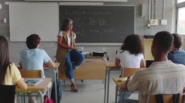 Genç nesil z öğrencileri lisede derse katılıyor. Genç siyah öğrenci ders sırasında kıdemli bayan öğretmene soru soruyor. Eğitim kavramı