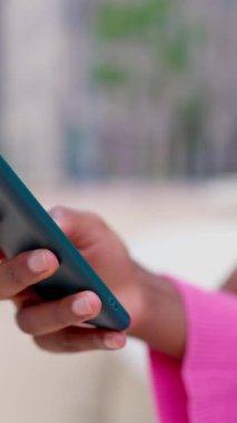 Dikey video. Genç kadın ellerini kaydırmak ve haber okumak için akıllı telefon kullanarak kapat. Tanımlanamayan bir kadın cep telefonunu tutuyor. Sosyal medya uygulamasında parmaklarıyla resimlere bakıyor.