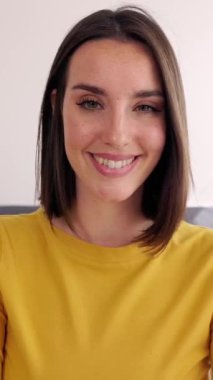 Dikey video. Genç ve güzel bir kadının video görüntülerine bakarken portresi. Memleketten sanal bir görüşme yapan mutlu milenyum kadınlarının POV ekranı. Telesekreter kavramı.