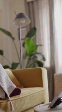 Genç bir kadının evdeki oturma odasında dizüstü bilgisayarla doktorla konuştuğu dikey HD video. Teletıp ve danışma online kavram