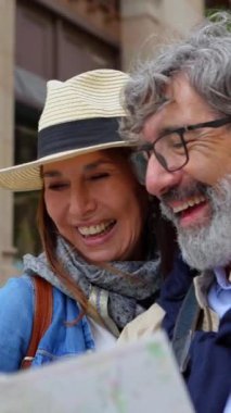 Birlikte tatilin tadını çıkaran turistik haritalı mutlu yaşlı çiftin dikey HD videosu. İki yetişkin emekli, Barselona 'da turistik bir yer arıyor. Yaşlılar yaşam tarzı konsepti. 
