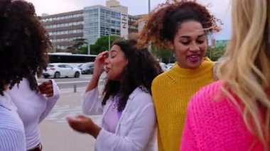 Çok ırklı genç bir grup kadın şehir caddesinde birlikte takılıyor. Entegrasyon ve kadın arkadaşlığı kavramı. Çeşitli kızlar konuşuyor, eğleniyor, gülüyor, eğleniyor.. 