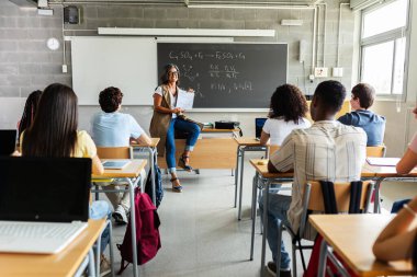 Genç nesil z öğrencileri lisede derse katılıyor. Genç siyah öğrenci ders sırasında kıdemli bayan öğretmene soru soruyor. Eğitim kavramı