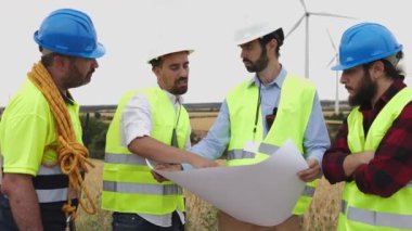 Rüzgar istasyonunda çalışan bir grup profesyonel mühendis türbin istasyonu kuracak. Yenilenebilir enerji kavramı.