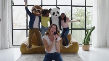 Genç bir grup çok ırklı öğrenci ev partisinde karaoke yaparken eğleniyor.