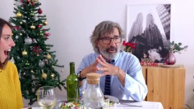 Mutlu aile, kış tatilinde yemek masasında Noel yemeğinin tadını çıkarıyor.