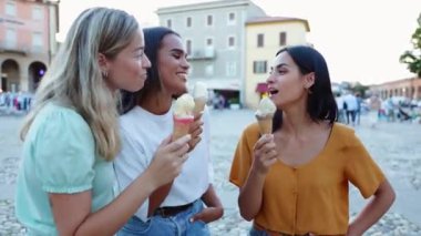 Üç genç turist yaz tatili boyunca birlikte dondurma yiyorlar. Kadın arkadaşlığı kavramı.