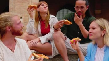 Millennial arkadaş grubu, İtalya 'da yaz tatilinin tadını çıkarırken birlikte pizza yiyorlar..