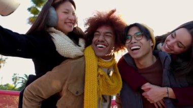 Mutlu bir grup genç arkadaş kış günü selfie çekiyorlar. Milenyum insanları sıcak kıyafetler giyip birlikte seyahat tatilinin tadını çıkarıyorlar. Arkadaşlık yaşam tarzı konsepti