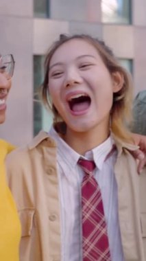 Açık havada eğlenen bir grup genç üniversite öğrencisinin dikey HD videosu. Çok ırklı en iyi bin yıllık arkadaşlar şehir sokaklarında boş vakitlerin tadını çıkarıyorlar. Gençlik toplumu ve arkadaşlık kavramı.