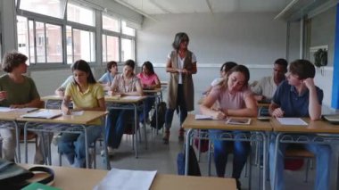 Kıdemli yetişkin öğretmen sınıftaki lise öğrencilerine bir ders veriyor. Eğitim kavramı.