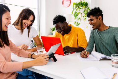 Evde dizüstü bilgisayarla çalışan bir grup mutlu öğrenci. Milenyum sınıf arkadaşları ortak konutta çalışma ya da hazırlık sınavları ya da üniversite grup ödevi yapıyor.