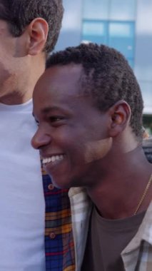 Binlerce yıllık mutlu genç arkadaş grubunun dikey HD videosu. Şehir caddesinde birlikte gülüyorlar. Çok ırklı insanlar birbirine sarılıyor ve birlikte vakit geçiriyorlar. Gençlik toplumu kavramı.