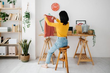 Genç girişimci Asyalı kadın müşteriye teslimat için paketler hazırlıyor. E-ticaret ve teslimat hizmeti kavramı.