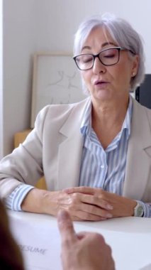 Üst düzey bir kadının iş görüşmesi sırasında HR erkek alıcısıyla konuştuğu dikey HD videosu. İş, kariyer ve iş fırsatları kavramı.