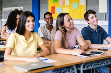Çok ırklı bir grup öğrenci, lisede bir öğretim görevlisini dinliyor. Gen Z Afrikalı çocuğa odaklan. Eğitim kavramı